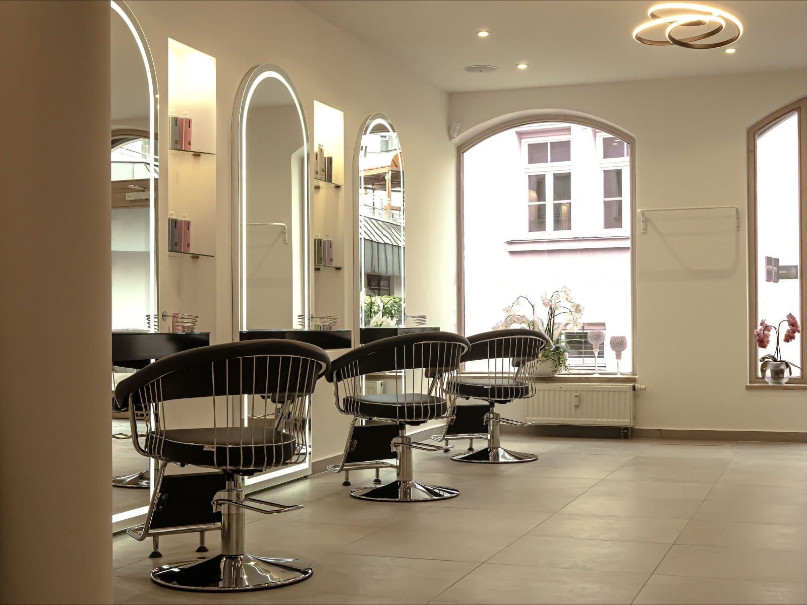 Friseursalon nach dem Innenausbau mit Trockenbau, runden Spiegelnischen und hellen Wänden